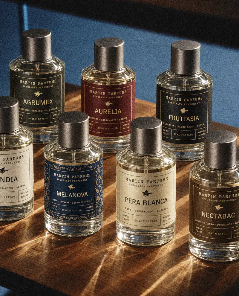Sette profumi Martin Parfums su un ripiano di legno
